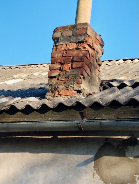 A brick chimney on a roof

Description automatically generated