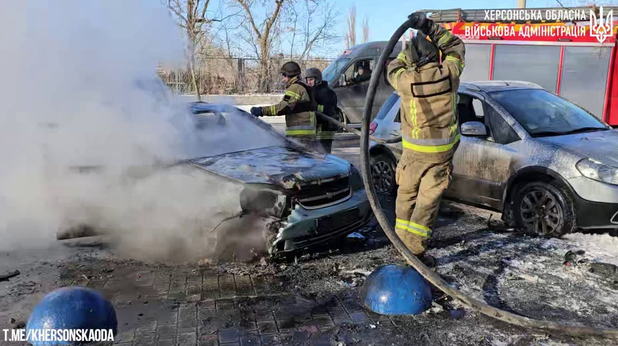 A firemen putting out a fire on a car

Description automatically generated