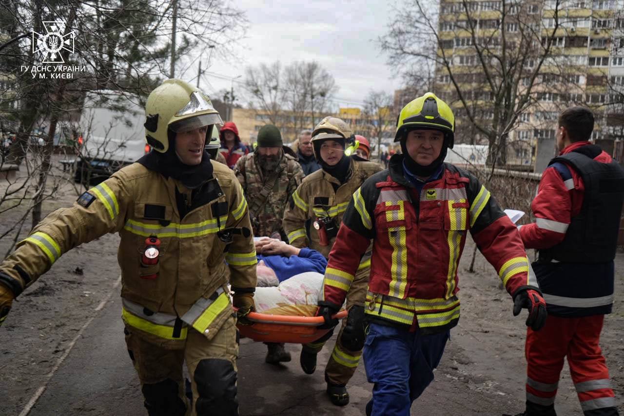 A group of firefighters carrying a person on a stretcher

Description automatically generated