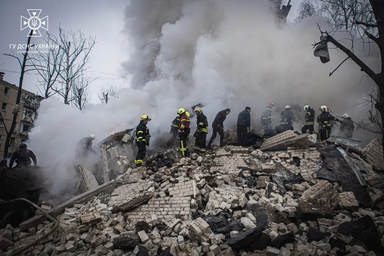 A group of firefighters on a pile of rubble

Description automatically generated