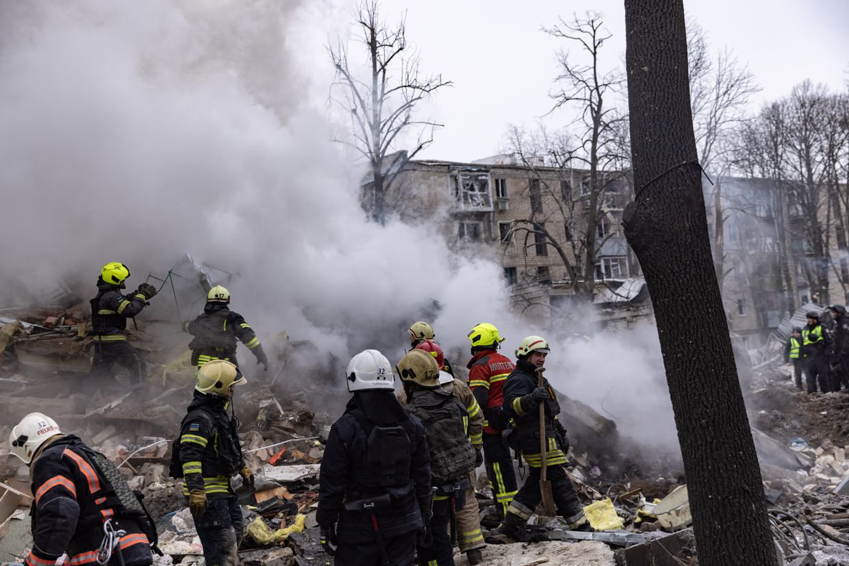 A group of firefighters standing in front of a building

Description automatically generated