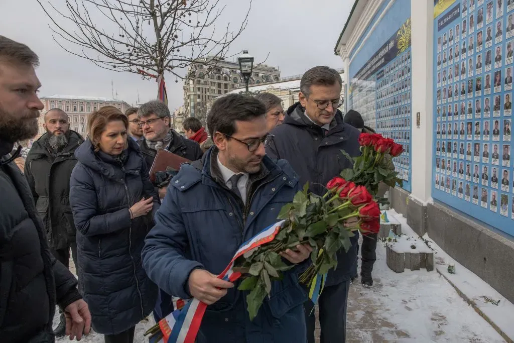 A group of people standing outside holding flowers

Description automatically generated