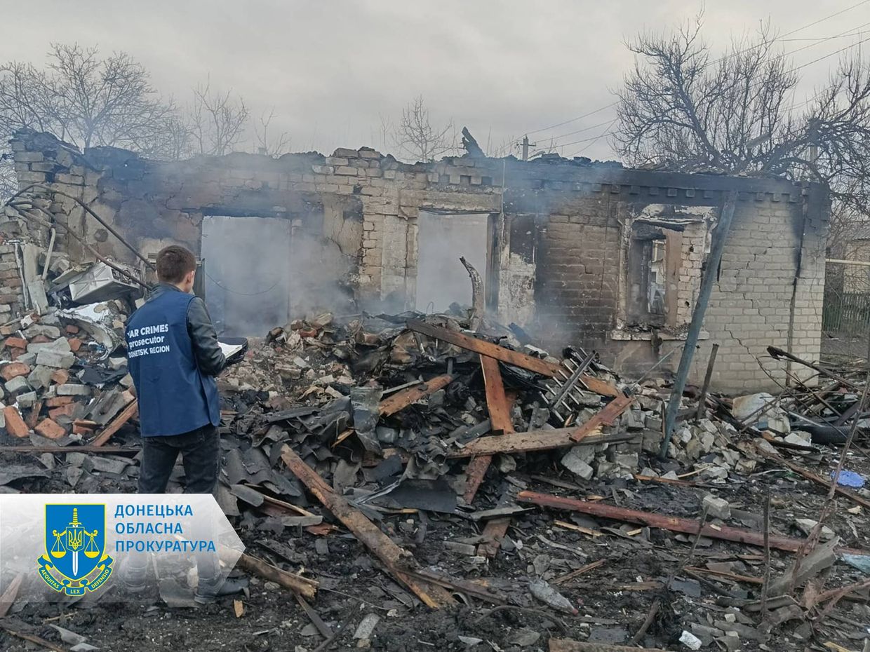 A person standing in front of a destroyed building

Description automatically generated