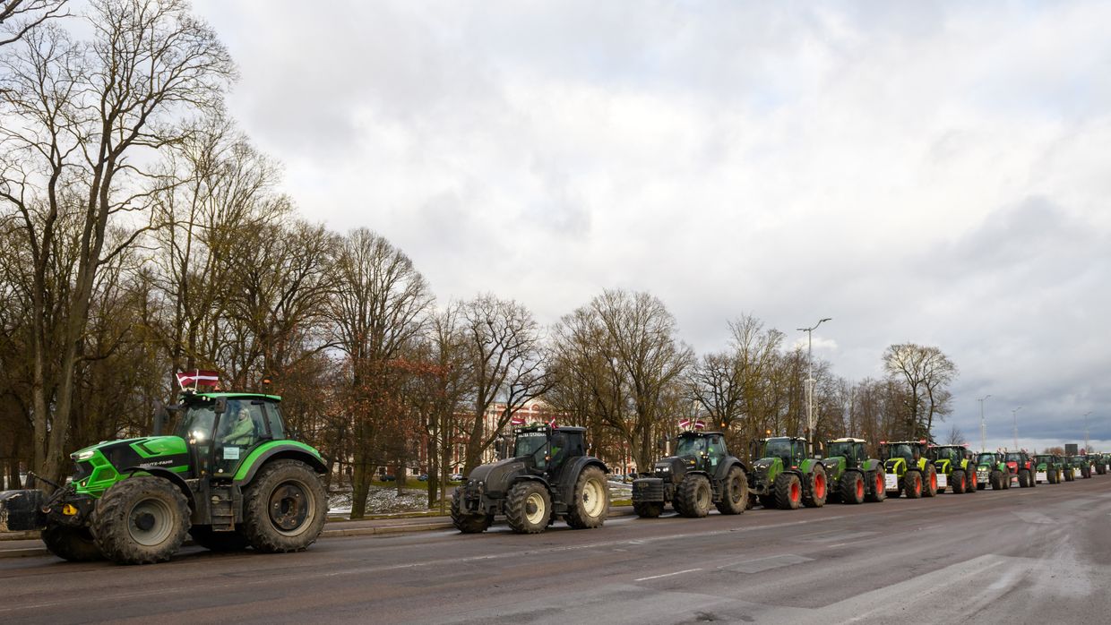 A row of tractors on the road

Description automatically generated