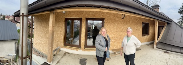 A couple of women standing in front of a building

Description automatically generated