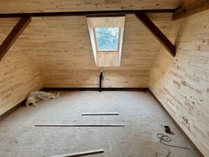 A dog lying on the floor of a room under construction Description automatically generated