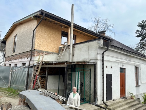 A person standing in front of a building

Description automatically generated