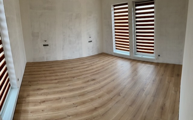 A room with a wood floor and windows

Description automatically generated