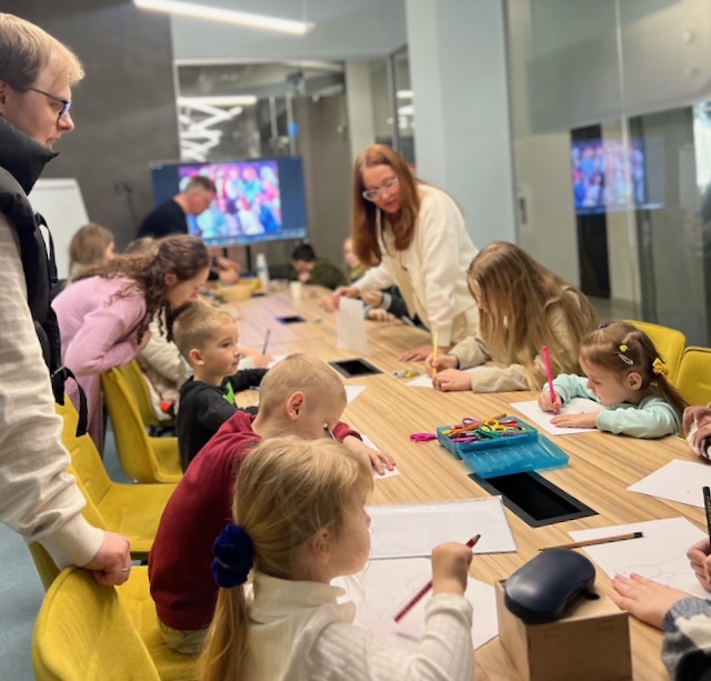 A group of children sitting at a table

Description automatically generated