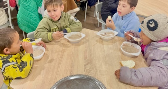 A group of kids eating at a table

Description automatically generated