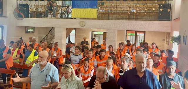 A group of people in orange vests

Description automatically generated