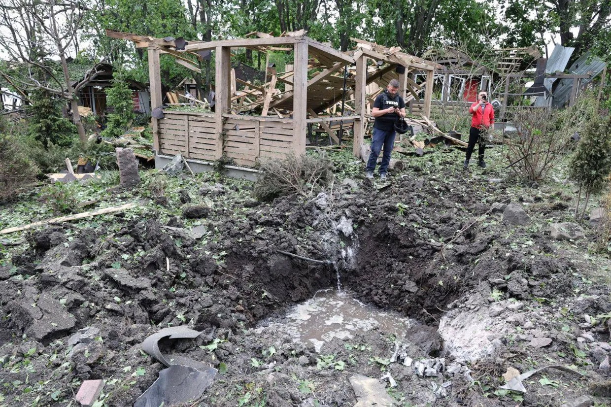 A group of people standing in a dirt pit

Description automatically generated