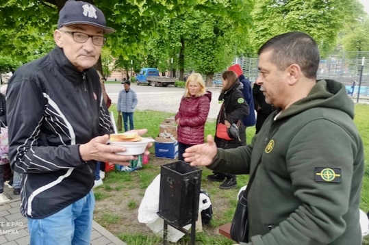 A person holding a plate of food

Description automatically generated