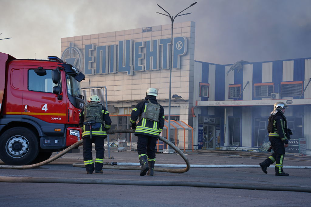 Firemen standing near a fire truck

Description automatically generated