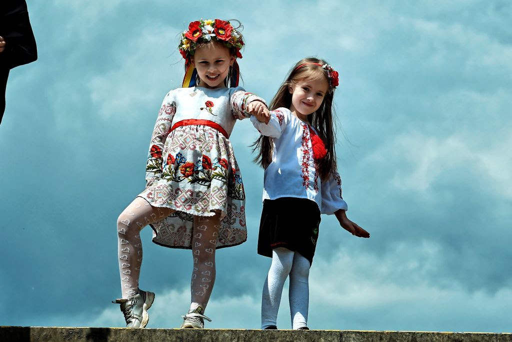 Two girls holding hands and posing for the camera

Description automatically generated