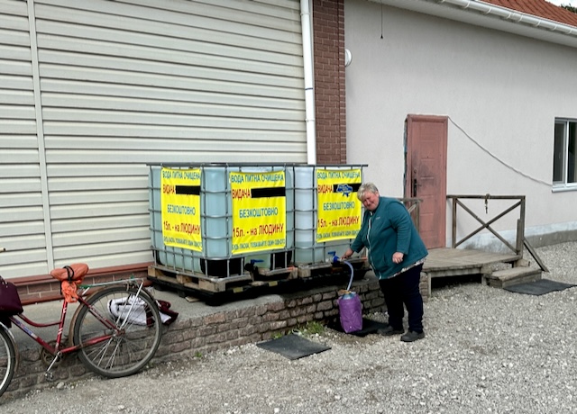 A person watering a water container

Description automatically generated with medium confidence