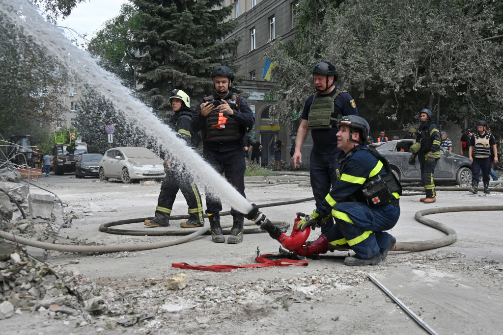 A group of firefighters spraying water

Description automatically generated