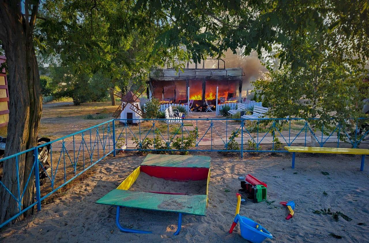 A playground with sandboxes and toys in front of a fire

Description automatically generated