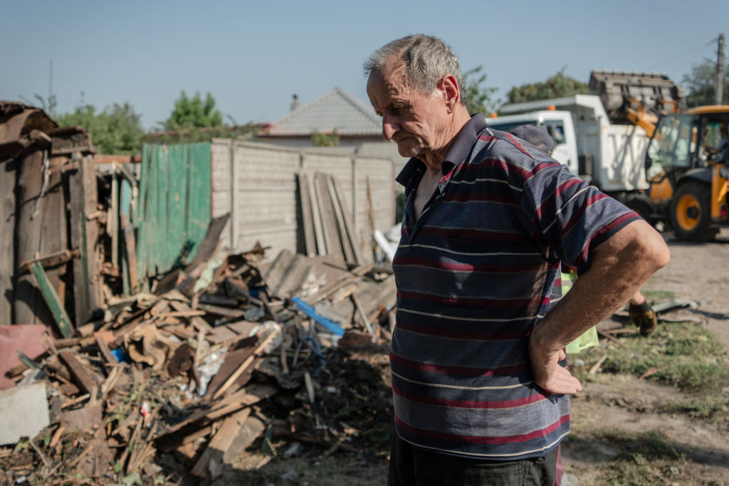 a statue of a man in front of a damaged building