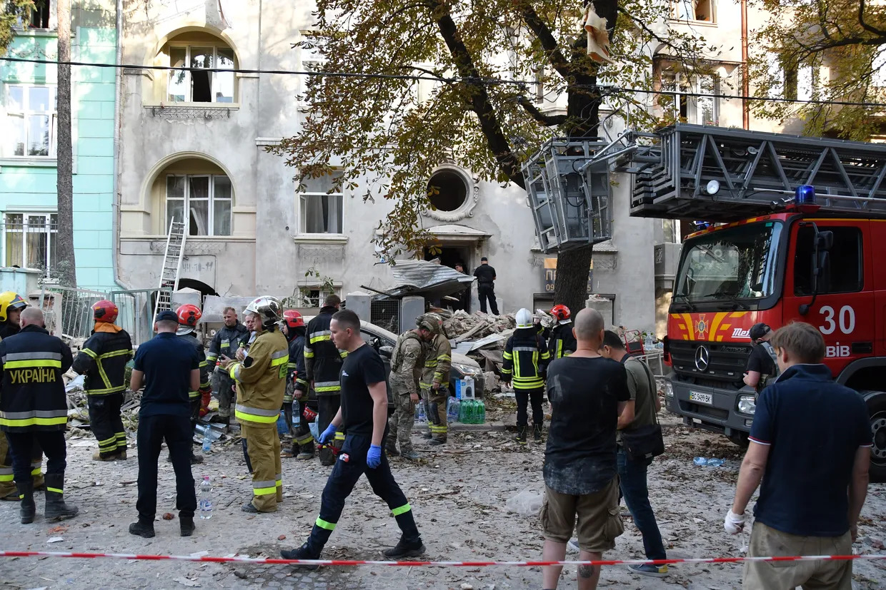 a statue of a man in front of a damaged building