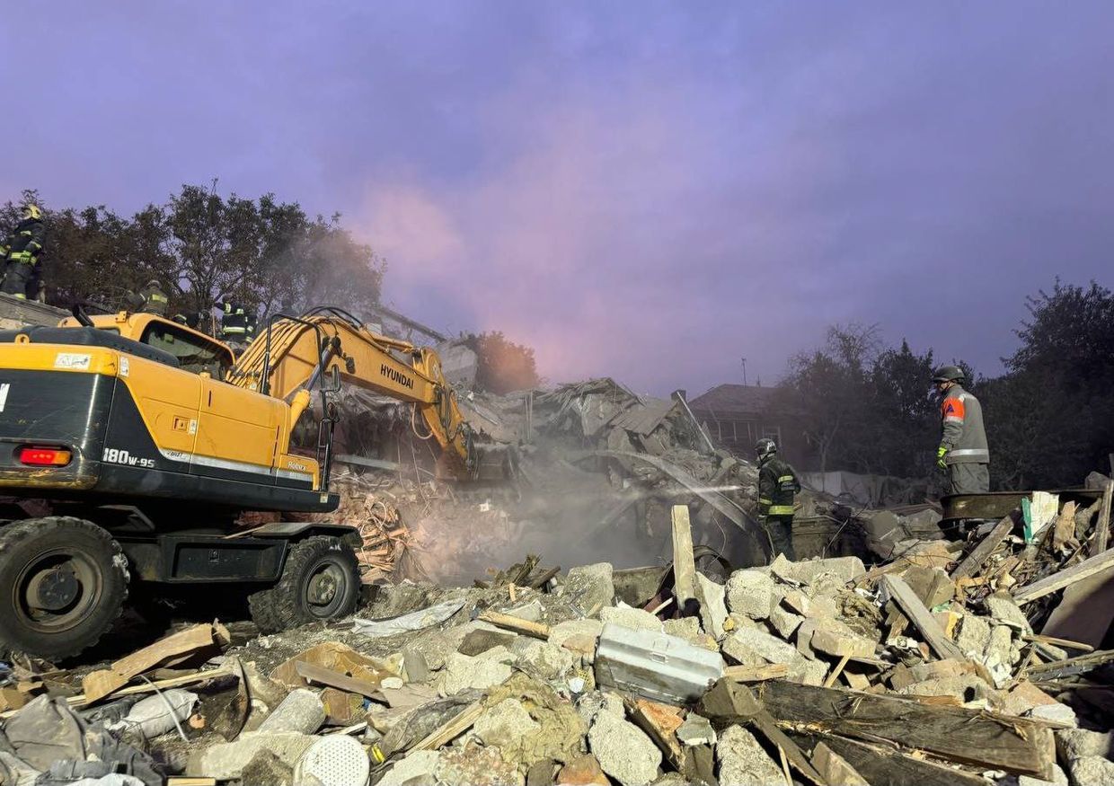 A construction vehicle and firemen working on a building

Description automatically generated with medium confidence