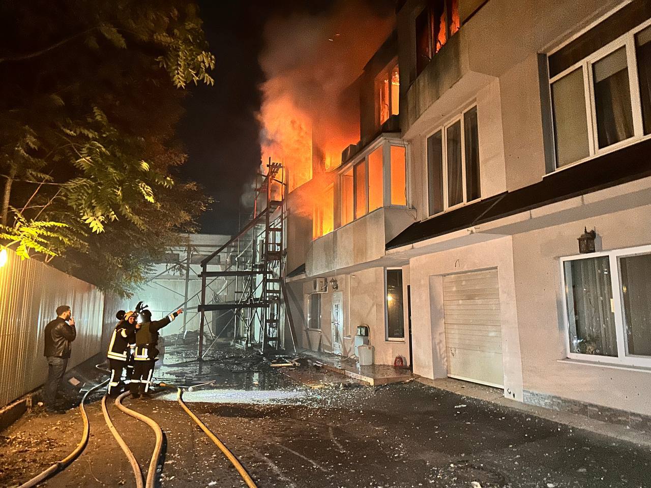 A fire fighters standing in front of a building

Description automatically generated