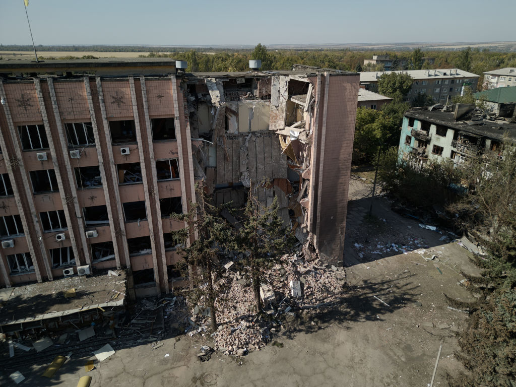 a statue of a man in front of a damaged building