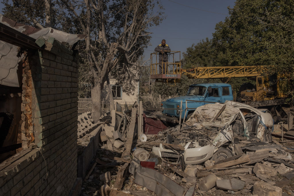 a statue of a man in front of a damaged building