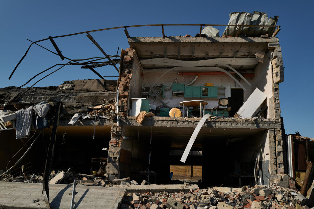 a statue of a man in front of a damaged building