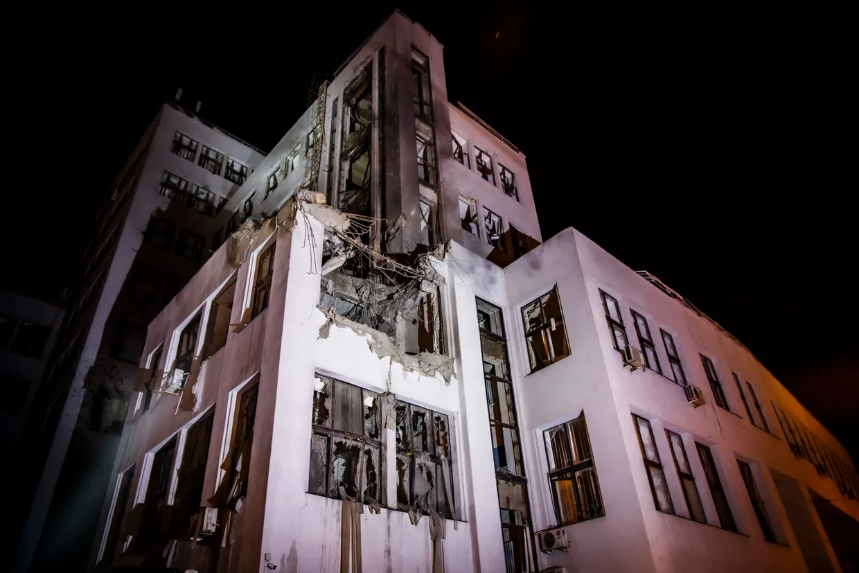 an apartment building at night with smoke coming out of the window