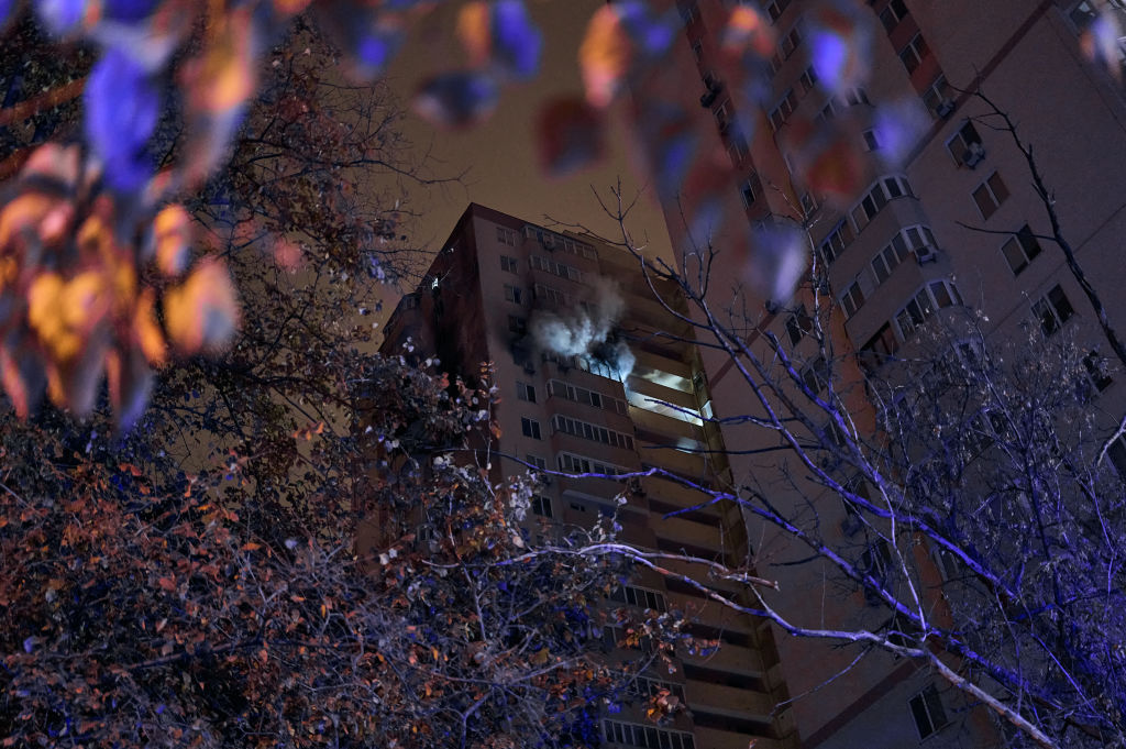 an apartment building at night with smoke coming out of the window