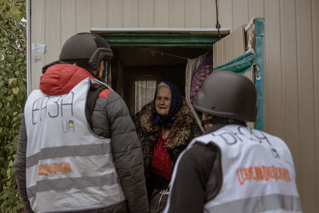 people wearing helmets are looking at a woman in a doorway