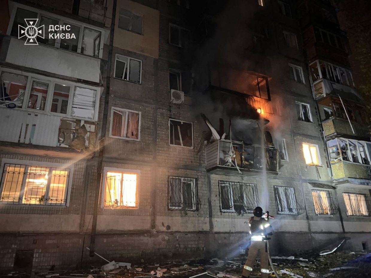 A firefighter standing in front of a building

Description automatically generated