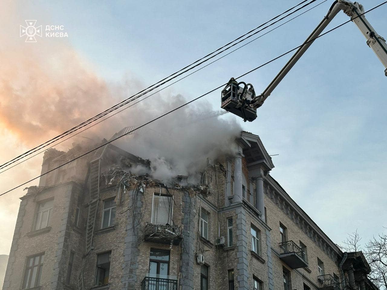 A crane on a building that has smoke coming out of it

Description automatically generated