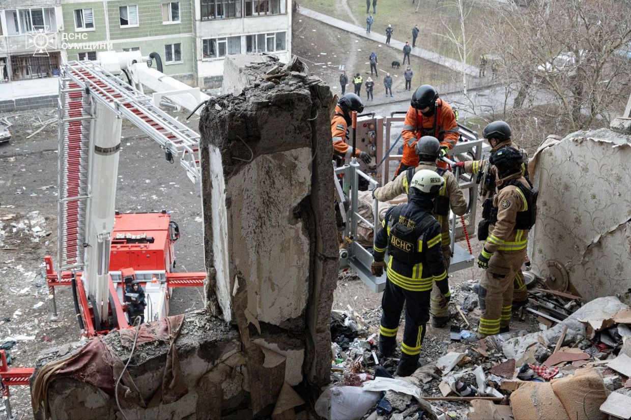 A group of firefighters working on a building

Description automatically generated