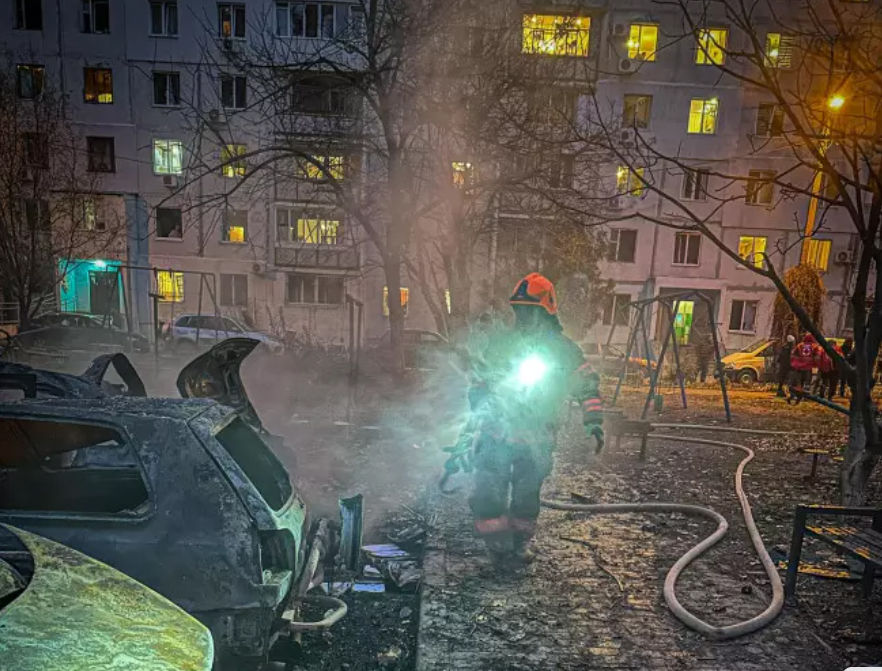 an apartment building at night with smoke coming out of the window