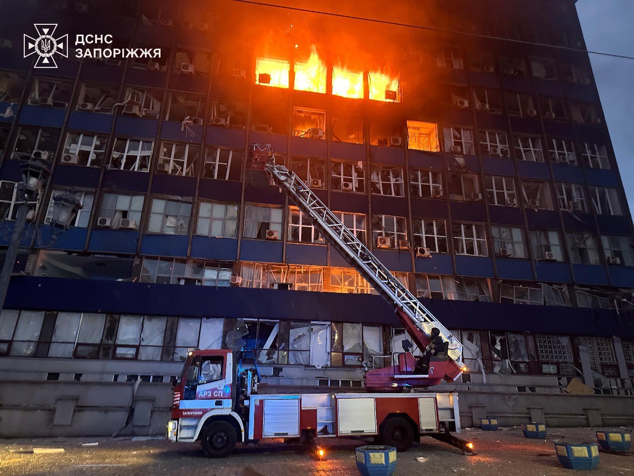 an apartment building at night with smoke coming out of the window