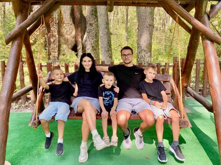 A group of people sitting on a swing

AI-generated content may be incorrect.