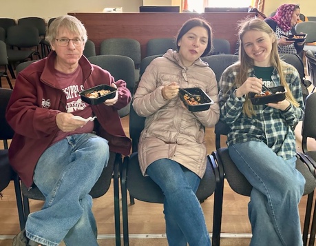 A group of people sitting in chairs eating food AI-generated content may be incorrect.