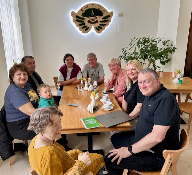 A group of people sitting around a table

AI-generated content may be incorrect.