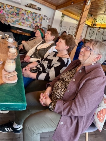 A group of women sitting at a table AI-generated content may be incorrect.