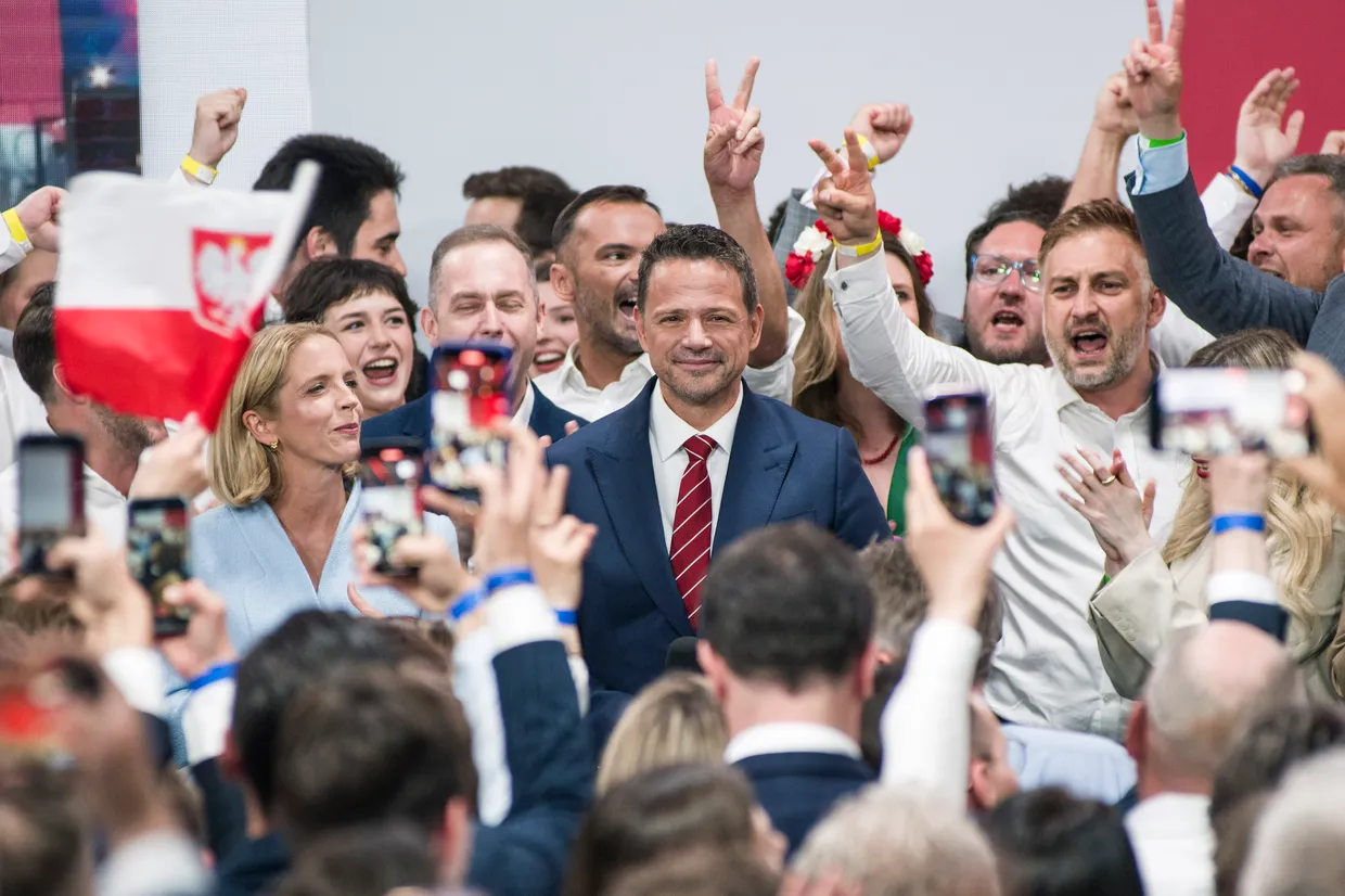 A person in a suit and tie with a crowd of people

AI-generated content may be incorrect.