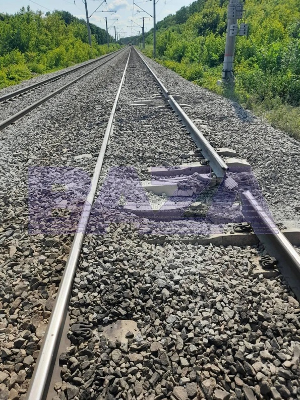 A train tracks with rocks and trees

AI-generated content may be incorrect.