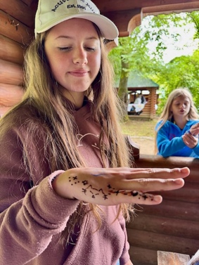 A child with a drawing on her hand

AI-generated content may be incorrect.