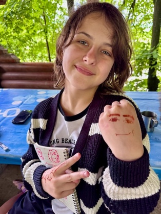 A child with a hand drawn on her hand

AI-generated content may be incorrect.