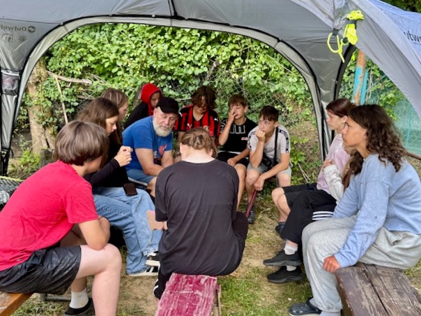 A group of people sitting in a tent

AI-generated content may be incorrect.