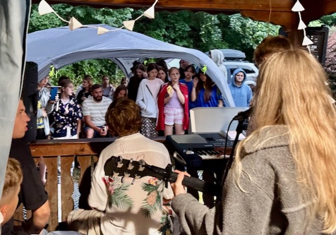 A person playing guitar in front of a crowd of people

AI-generated content may be incorrect.