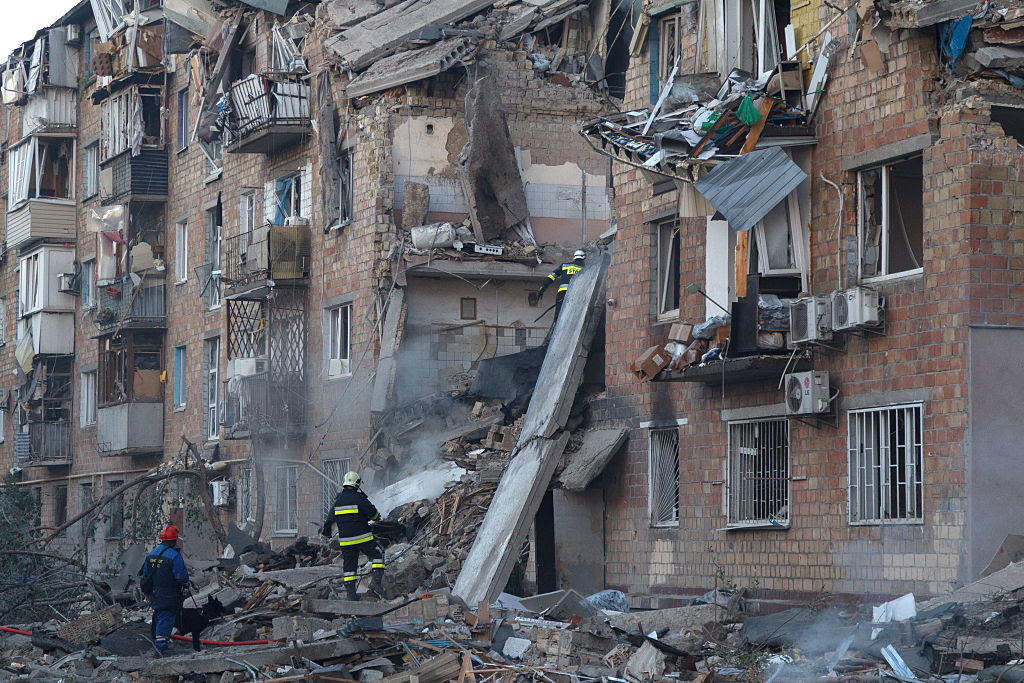 A group of firefighters standing in front of a destroyed building

AI-generated content may be incorrect.