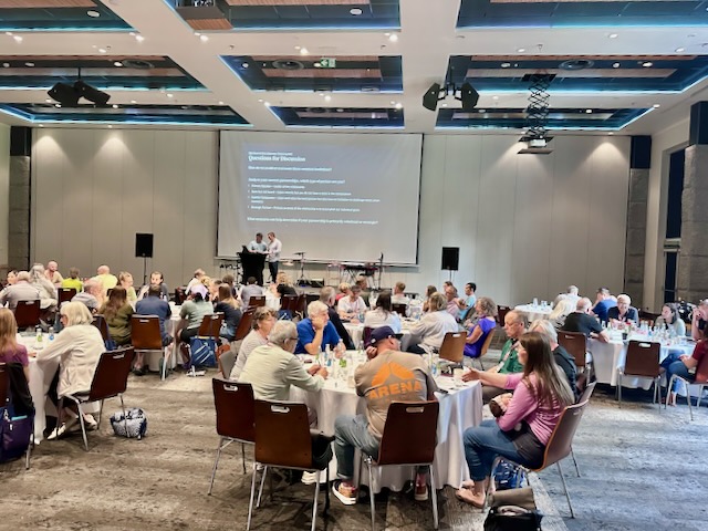 A group of people sitting at tables in a room

AI-generated content may be incorrect.