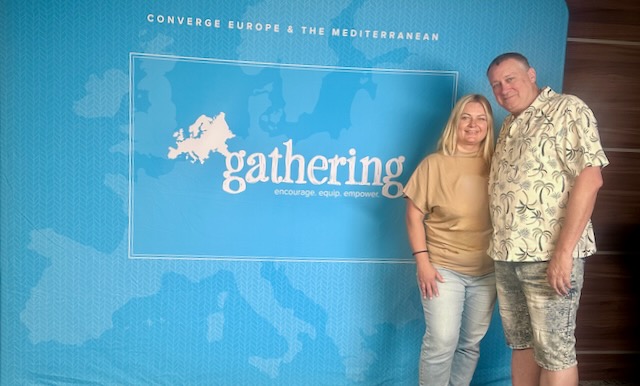 A person and person standing in front of a blue sign

AI-generated content may be incorrect.